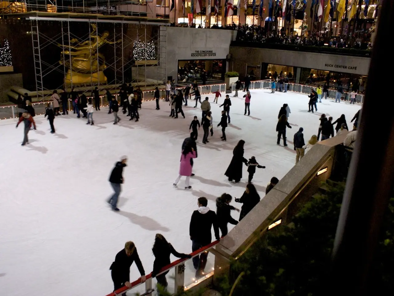 In this image there are so many people doing snow skating on the snow, which is in the middle of...