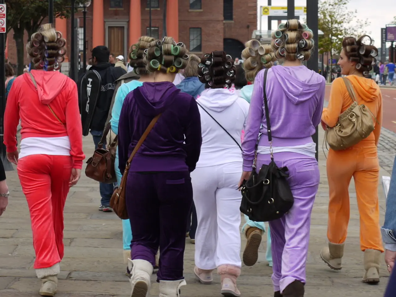 There is lot of girls walking towards the building wearing same type of costume in different colors...