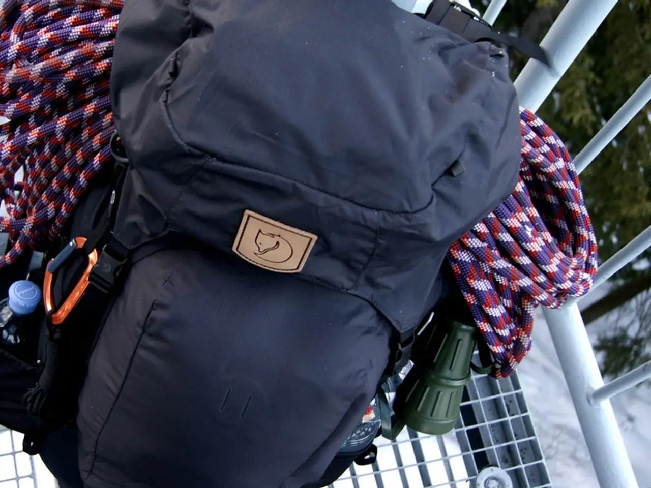 Here we can see a travel bag, climbing ropes in it and at the left side we can see a bottle and at...