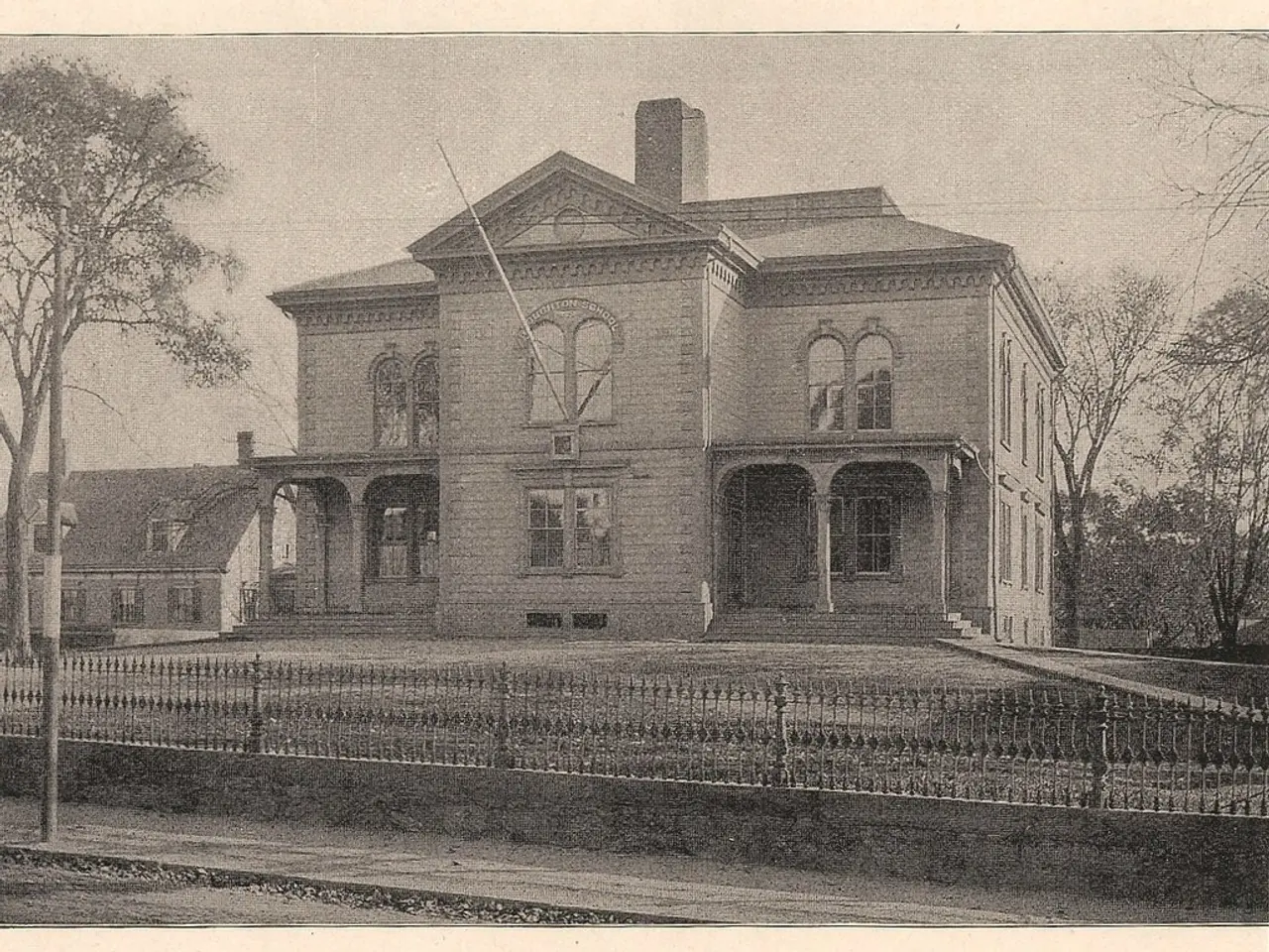 There is a fencing, pole, trees and buildings.