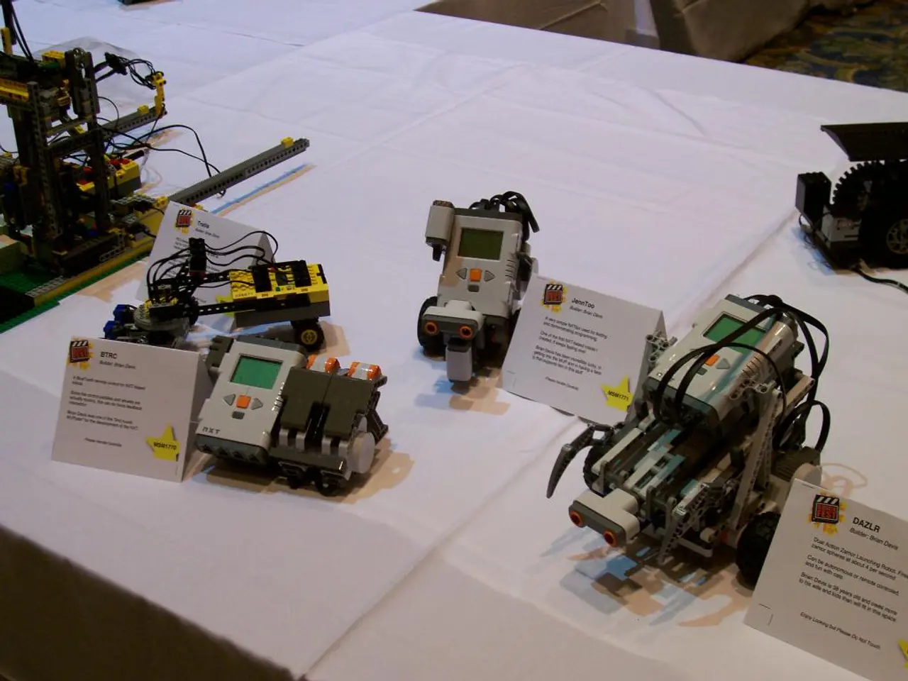 In this image I can see few machines and boards on the white color cloth. The machines are in gray...