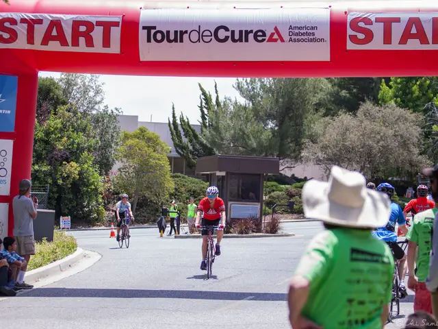 This is a place where the people are passing on bicycles and some people sitting on the foot path...