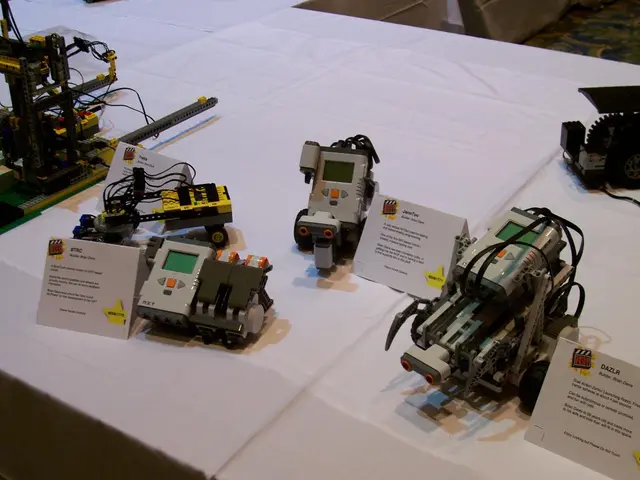 In this image I can see few machines and boards on the white color cloth. The machines are in gray...